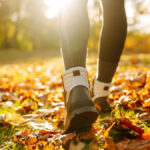 Woman walking through leaves in the fall. Concept of being in charge of your own happiness